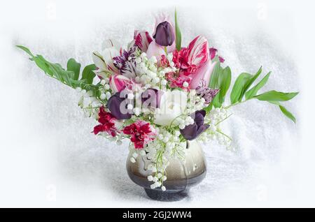 Heller Hintergrund mit einem Blumenstrauß aus Frühlingsblumen in einer Keramikvase Stockfoto