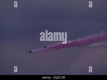 Zwei der Red Arrows-Teams, die sich auf dem Weg über das Meer befinden und Rauchspuren hinterlassen. Stockfoto