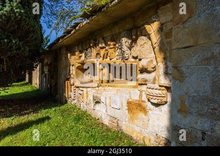 Fragmente der geschnitzten Steinarbeiten der Hailes Abbey, eingebettet in die Wand des Friedhofs der St. Peter’s Church neben dem Stanway House, Cotswolds, England Stockfoto