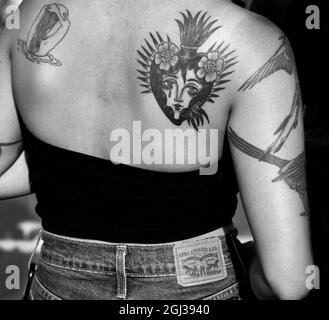 Eine junge Frau mit einem Herz-Jesu-Tattoo auf ihrem Rücken in Santa Fe, New Mexico. Stockfoto