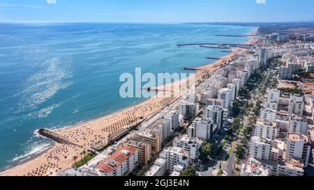 Schöne Luftbilder der portugiesischen Touristenstadt Quarteira. An der Küste während der Strandsaison mit Touristen, die sich sonnen. Stockfoto