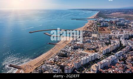 Schöne Luftbilder der portugiesischen Touristenstadt Quarteira. An der Küste während der Strandsaison mit Touristen, die sich sonnen. Stockfoto