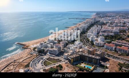 Schöne Luftbilder der portugiesischen Touristenstadt Quarteira. An der Küste während der Strandsaison mit Touristen, die sich sonnen. Stockfoto