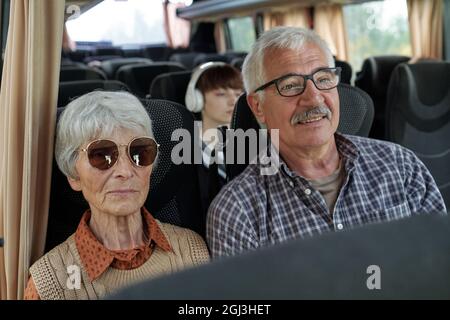Inhalt Älteres kaukasisches Paar mit grauen Haaren sitzt im Bus, während sie zusammen unterwegs sind Stockfoto