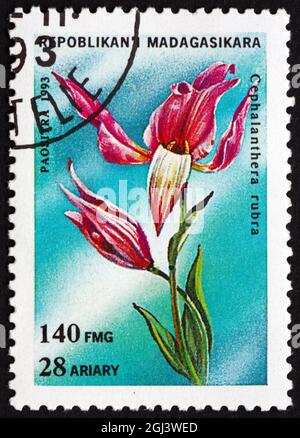 MALAGASY - UM 1993: Eine in Malagasy, Madagaskar gedruckte Marke zeigt Rotes Helleborine, cephalanthera rubra, Orchidee, um 1993 Stockfoto