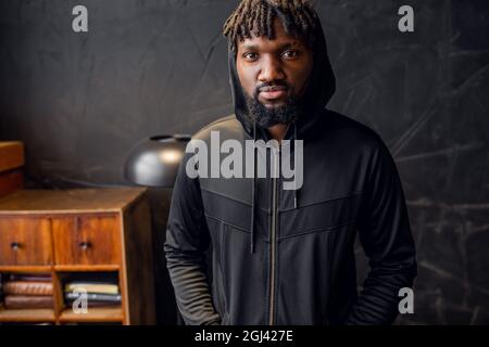 Porträt eines jungen afroamerikanischen Mannes in Sportkleidung in einem Haube Stockfoto