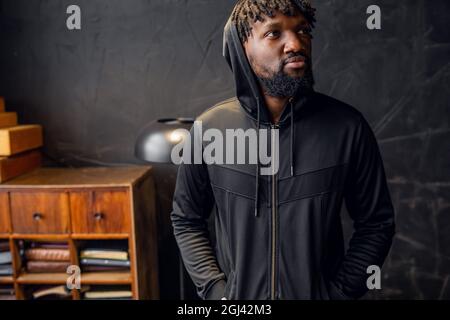 Porträt eines jungen afroamerikanischen Mannes in Sportkleidung in einem Haube Stockfoto