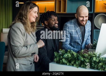 Junger Teamleiter schwarzer Mann Brainstorming mit Geschäftsmann Kollegen mit Laptop-Computer. Glückliche erfolgreiche Menschen Stockfoto