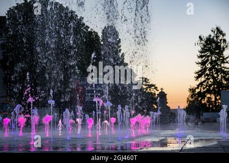 NIS, Serbien - 07. September 2021 Brunnen auf dem Stadtplatz mit violettem Wasser bei Sonnenuntergang an einem Herbsttag in der Stadt Nis Stockfoto