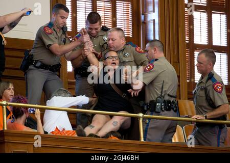 Austin, Texas, USA. Juli 2013. Nach einer abschließenden Abstimmung im Repräsentantenhaus über ein Gesetz HB2, das Abtreibungsunternehmen in Texas weiter einschränkt, wird ein Protestler von der öffentlichen Tribüne gezogen. Befürworter von Leben und Wahlfreiheit haben das texanische Kapitol in den letzten zwei Wochen mit Märschen und Protesten überflutet. (Bild: © Bob Daemmrich/ZUMA Press Wire) Stockfoto