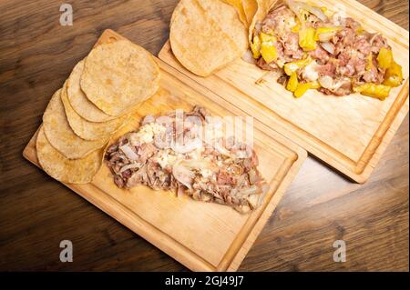 Würzige Fajitas mit Rind- und Hühnchen auf einem Holztablett Stockfoto