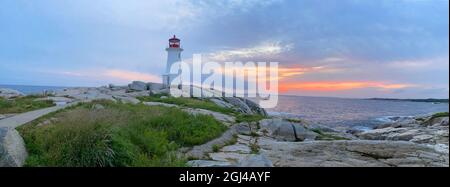 Peggy’s Cove Lighthouse, beleuchtet bei Sonnenuntergang mit einem dramatischen Himmel im Vordergrund, Nova Scotia, Kanada
