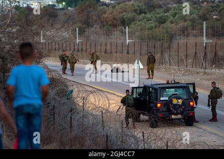 Jenin. September 2021. Israelische Soldaten bewachen am 8. September 2021 den Sicherheitszaun in der Nähe der Stadt Jenin im Westjordanland. Die israelische Armee sagte am Mittwoch, dass sie die Schließung im Westjordanland und im Gazastreifen aufgrund einer Jagd auf sechs palästinensische Flüchtlinge, die am Montag ihren Weg aus dem Gefängnis getunnelt haben, verlängern würde. Quelle: Gil Eliyahu /JINI via Xinhua/Alamy Live News Stockfoto