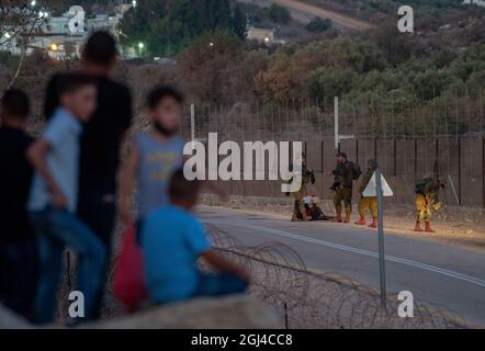 Jenin. September 2021. Israelische Soldaten bewachen am 8. September 2021 den Sicherheitszaun in der Nähe der Stadt Jenin im Westjordanland. Die israelische Armee sagte am Mittwoch, dass sie die Schließung im Westjordanland und im Gazastreifen aufgrund einer Jagd auf sechs palästinensische Flüchtlinge, die am Montag ihren Weg aus dem Gefängnis getunnelt haben, verlängern würde. Quelle: Gil Eliyahu /JINI via Xinhua/Alamy Live News Stockfoto