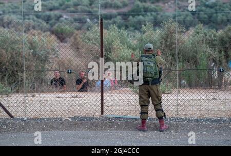 Jenin. September 2021. Ein israelischer Soldat bewacht am 8. September 2021 den Sicherheitszaun in der Nähe der Stadt Jenin im Westjordanland. Die israelische Armee sagte am Mittwoch, dass sie die Schließung im Westjordanland und im Gazastreifen aufgrund einer Jagd auf sechs palästinensische Flüchtlinge, die am Montag ihren Weg aus dem Gefängnis getunnelt haben, verlängern würde. Quelle: Gil Eliyahu /JINI via Xinhua/Alamy Live News Stockfoto