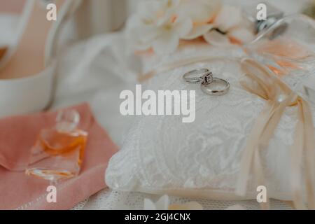 Kissen mit einem Paar Eheringe auf einem verschwommenen anderen Hochzeit Vorrat Hintergrund Stockfoto
