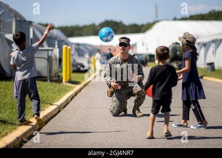 Quantico, Usa. September 2021. US Marine CPL. Hunter Degnan spielt Ball mit afghanischen Kindern, die von Kabul zur Marine Corps Base Quantico evakuiert wurden, 7. September 2021 in Quantico, Virginia, USA. Quantico stellt den Afghanen vorübergehend Wohnraum zur Verfügung, da sie für die Einwanderung verarbeitet werden. Quelle: TIA Dufour/US Marines Photo/Alamy Live News Stockfoto