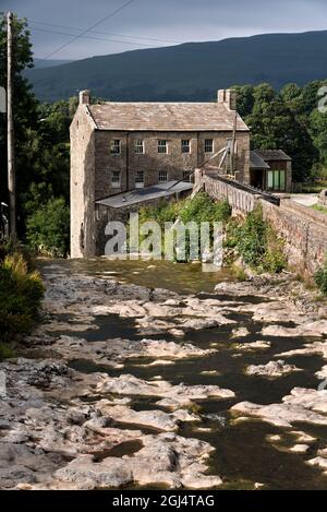 Die historische Gayle Mill, ein denkmalgeschütztes Gebäude, in der Nähe von Hawes, Wensleydale, Yorkshire Dales National Park, Großbritannien. Gayle Beck lieferte Wasserkraft für die Mühle. Stockfoto