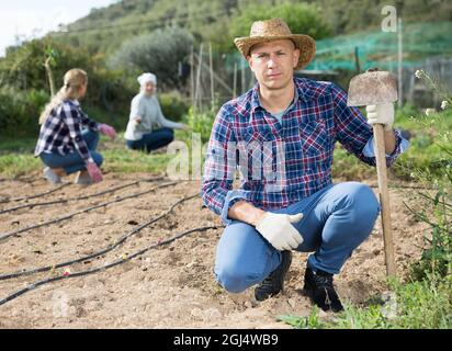 Gärtner mit Hacke im Kleinbetrieb Stockfoto