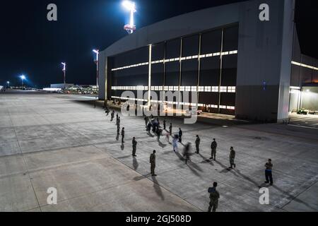 US Air Force Airmen, die dem 721. Aerial Port Squadron zugewiesen wurden, bilden ein Gate, als Evakuierte aus Afghanistan an Bord eines Fluges von Delta Airlines auf dem Ramstein Air Base, Deutschland, 25. August 2021. Flugzeuge der zivilen Reserve Air-Flotte werden für die Weiterbewegung von Passagieren aus temporären sicheren Häfen und Zwischenstaffelbasen eingesetzt. (USA Air Force Foto von Tech. Sgt. Donald Barnec) Stockfoto