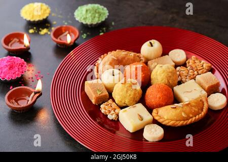 Indische Frau nimmt Diwali Süßigkeiten Gujiya peda barfi Indische süße Dessert mithai Festival Gericht Dussehra Holi ganesh chaturthi RAM navami Durga pooja Stockfoto