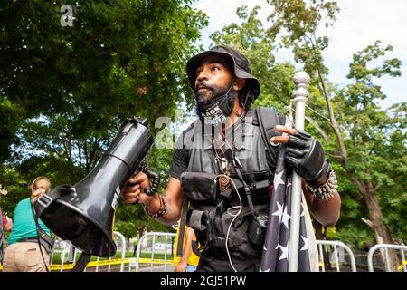 Richmond, VA, USA, 8. September 2021. Im Bild: Japhari Jones, ein Aktivist in Richmond, steht vor den Barrikaden, nachdem er unmittelbar nach der Entfernung der Statue des konföderierten Generals Robert E. Lee von der Monument Avenue von der Staatspolizei von Virginia aus dem Schutzgebiet eskortiert wurde. Das oberste Gericht von Virginia entschied letzte Woche, dass das sechsstöckige Denkmal entfernt werden könnte. Es muss noch entschieden werden, ob das mit Anti-Rassismus-Graffiti bedeckte Podest angesichts seiner prominenten Rolle beim Anti-Rassismus-Aufstand von 2020 in Richmond entfernt wird. Kredit: Allison Bailey / Alamy Live Nachrichten Stockfoto