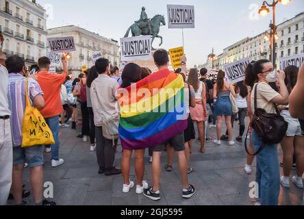 Während der Demonstration wurden die Demonstranten mit einer Regenbogenfahne gewickelt.das Movimiento Marica Madrid setzt die Konzentration an der Puerta del Sol fort, um die homophoben Aggressionen und gegen das LGTBI-Kollektiv zu verurteilen, auch nachdem bekannt wurde, dass die Aggression, die am vergangenen Sonntag in Malasaña von einem jungen Mann erlitten wurde, einvernehmlich war. Ein 20-jähriger schwuler Mann meldete der Polizei, dass er am vergangenen Sonntag von einer Gruppe von verhaufelten Männern am Eingang seines Wohnblocks im Stadtteil Malasaña angegriffen wurde. Heute hat er sich zurückgezogen und der Polizei gesagt, dass die Wunden nicht das Ergebnis eines Assaus waren Stockfoto