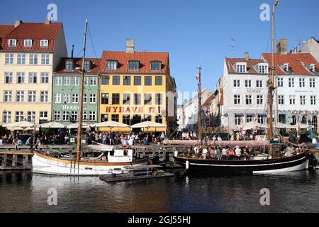 Kopenhagen, Dänemark. September 2021. Passanten spazieren entlang Nyhavn, dem Hafen mit seinen bunten kleinen Häusern, die bei Touristen beliebt sind. Dänemark hebt die verbleibenden Corona-Maßnahmen, die am 10. September in Kraft sind, auf. Schon jetzt fühlt sich das Leben in der Hauptstadt Kopenhagen fast restriktionsfrei an. (To dpa 'Denmark says Auf Wiedersehen to Last Corona restrictions') Quelle: Steffen TRUMPF/dpa/Alamy Live News Stockfoto