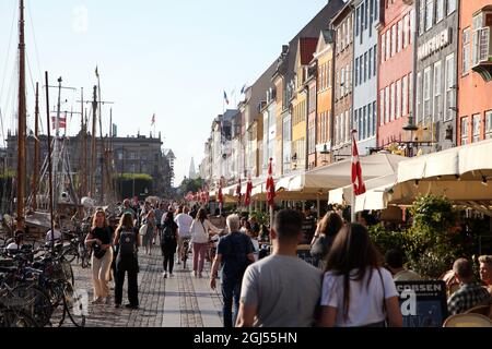 Kopenhagen, Dänemark. September 2021. Passanten spazieren entlang Nyhavn, dem Hafen mit seinen bunten kleinen Häusern, die bei Touristen beliebt sind. Dänemark hebt die verbleibenden Corona-Maßnahmen, die am 10. September in Kraft sind, auf. Schon jetzt fühlt sich das Leben in der Hauptstadt Kopenhagen fast restriktionsfrei an. (To dpa 'Denmark says Auf Wiedersehen to Last Corona restrictions') Quelle: Steffen TRUMPF/dpa/Alamy Live News Stockfoto