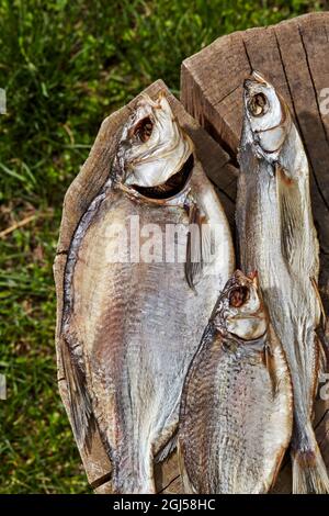 Gesalzener, luftgetrockneter Fisch, der auf einem Holzstumpf im Freien liegt Stockfoto