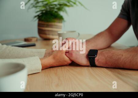 Nahaufnahme des kaukasischen Paares, das sich in der Küche die Hände hält Stockfoto