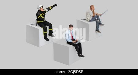 Zusammengesetztes Bild von drei Arbeitern, die auf einem Würfel auf grauem Studioboden sitzen. Collage Stockfoto