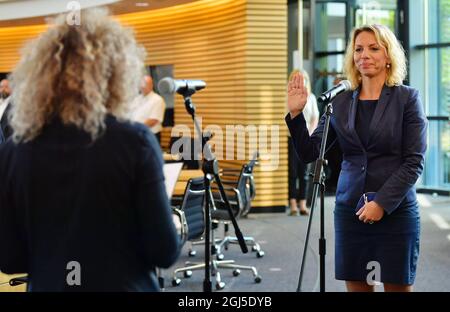 Erfurt, Deutschland. September 2021. Susanna Karawanskij (die Linke) reicht im Plenarsaal des Thüringer landtags während ihrer Vereidigung als Ministerin für Landwirtschaft und Infrastruktur die Hand. Der 41-Jährige war bereits Staatssekretär im Ministerium für Infrastruktur. Ihr Ministerium ist auch für Bau und Transport zuständig. Quelle: Martin Schutt/dpa-Zentralbild/dpa/Alamy Live News Stockfoto