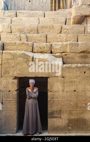 Oberägypten, Westufer des Nils. Tempel von Edfu. Ägyptischer Mann in traditioneller Robe, genannt Jellabiya. Steht am Eingang. (Redaktionelle Verwendung O Stockfoto