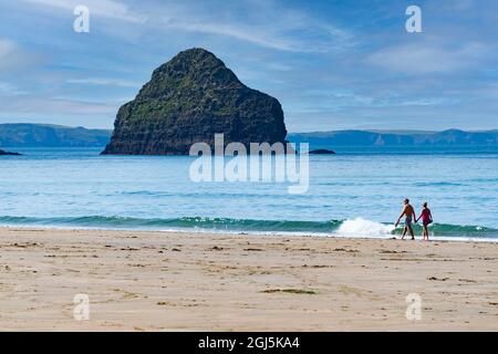 Ein Paar mittleren Alters ging Hand in Hand am Strand von Trebarwith Strand, Cornwall, Großbritannien Stockfoto