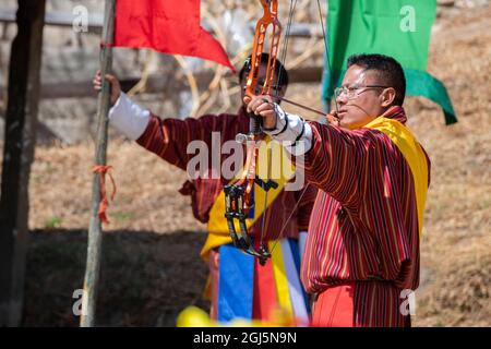 Bhutan, Paro. Bogenschießen Wettbewerb, Bhutans National Sport. Bogenschütze in traditioneller Kleidung. (Nur Für Redaktionelle Zwecke) Stockfoto