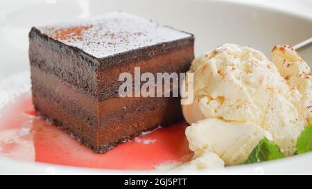 Hausgemachter Schokoladenkuchen mit Vanilleeis und Himbeersoße aus der Nähe. Hochwertige Fotos Stockfoto