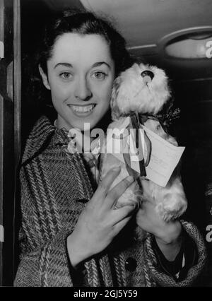 Sylvia Cheeseman , nationale 100 und 200 Meter-Meisterin , mit '' OWD Bob '' das Hundemaskottchen, das dem Team von der Amateur Athletic Association vorgestellt wurde, als sie die Waterloo Station verließ. Dezember 1949 Stockfoto