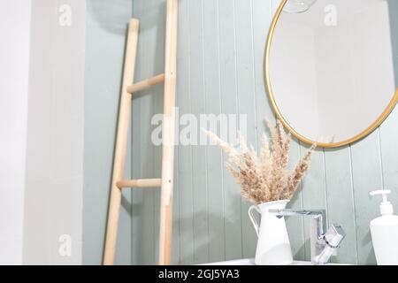 Ein modernes Badezimmer mit minimalistischer Einrichtung, ein Waschbecken und ein runder Spiegel in einem stilvollen Badezimmer. Innenarchitektur. Hochwertige Fotos Stockfoto