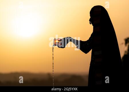 Indien, Gujarat, Bhuj, Great Rann of Kutch, Ahir Tribe. Eine Ahir-Frau bringt den Gottheiten ein Opfer. Stockfoto