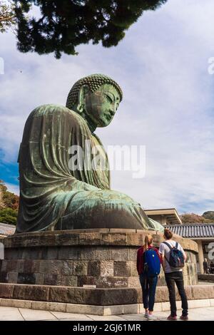 Zwei Touristen betrachten den Großen Buddha, Daibutsu, Kamakura, Japan Stockfoto