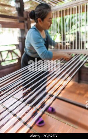 Laos, Vientiane. Lao Textile Museum, Weber arbeitet traditionellen Lao Webstuhl. Stockfoto