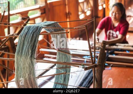 Laos, Vientiane. Lao Textile Museum, Weber arbeitet traditionellen Lao Webstuhl. Stockfoto