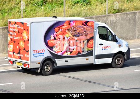 Seite und Rückseite des Tesco Supermarkts Transport van Lebensmittel Lieferkette Einzelhandel Geschäft Lieferung von Online-Internet-Lebensmitteleinkauf auf einer britischen Autobahn Stockfoto