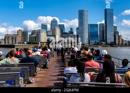 Ein Kreuzfahrtboot auf der Themse nähert sich Canary Wharf, London, Großbritannien. Stockfoto