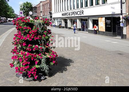 Im Juli, als Großbritannien aus der Pandemie-Blockierung in England herauskommt, werden in der Brentwood High Street Sommerblumen ausgestellt und Marks und Spencer nur wenige Käufer laden Stockfoto