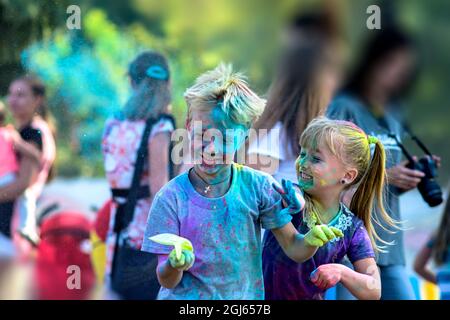 Holi ist ein Urlaub. Junge und Mädchen, die Spaß mit trockenen Farben Stockfoto