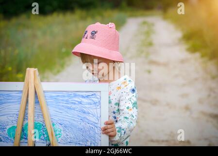 Das Mädchen zeichnet ein Bild von der Straße Stockfoto