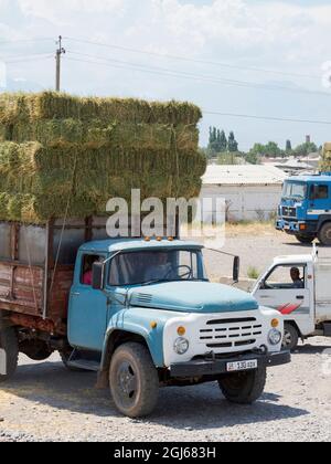 Verkauf und Verladung von Heu. Der Viehmarkt in Tokmok, einer Stadt am Fuße des Tien Shan in der Nähe von Bischkek, Kirgisistan. (Nur Für Redaktionelle Zwecke) Stockfoto