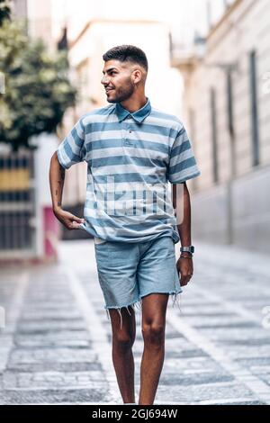 Vertikales Porträt eines Mannes, der in einer Stadt abgelenkt zur Seite schaut Stockfoto